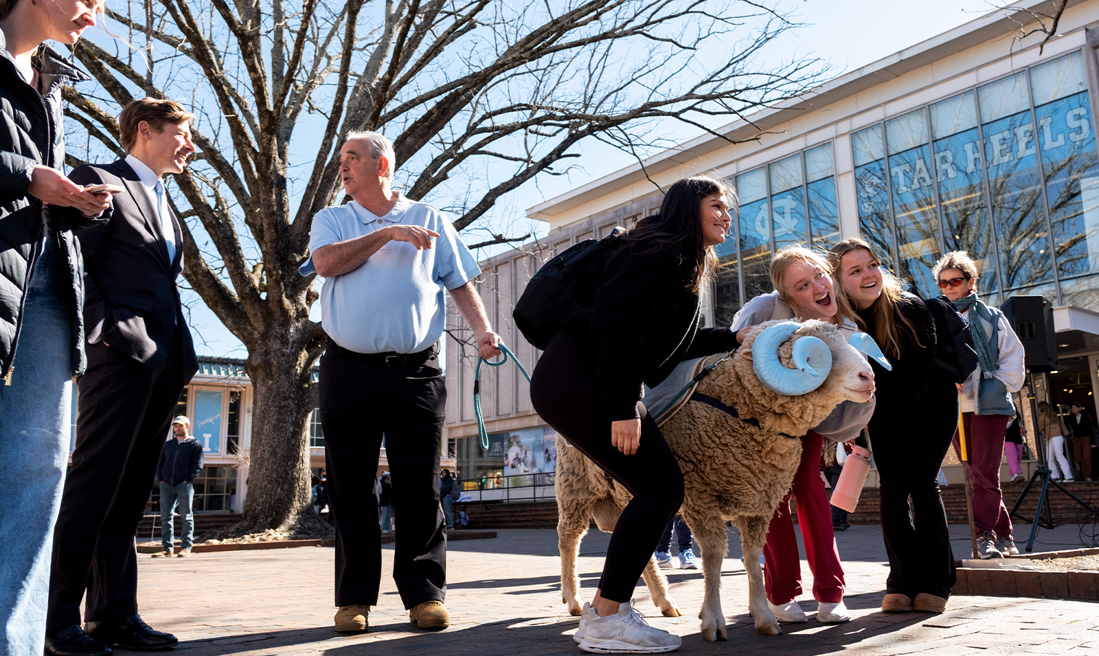 Students posing with a live ram mascot, Rameses, at the Pit on the campus of UNC-Chapel Hill.